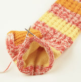 addiSockwonder Lace circular knitting needle 25cm - 710-7 - Knitted multicolored sock with a needle on a white background